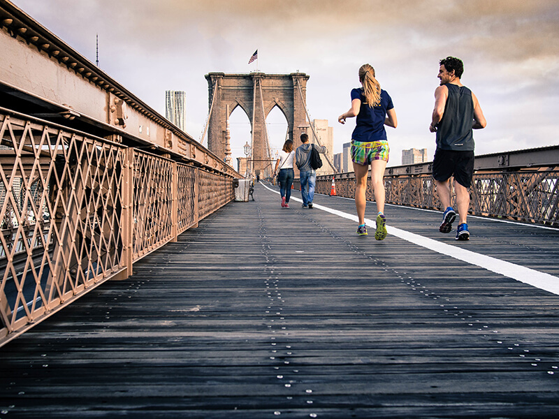 people running on a bridge