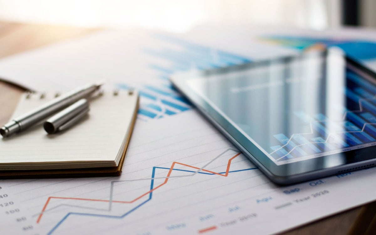 Tablet and paper with lots of graphs on 