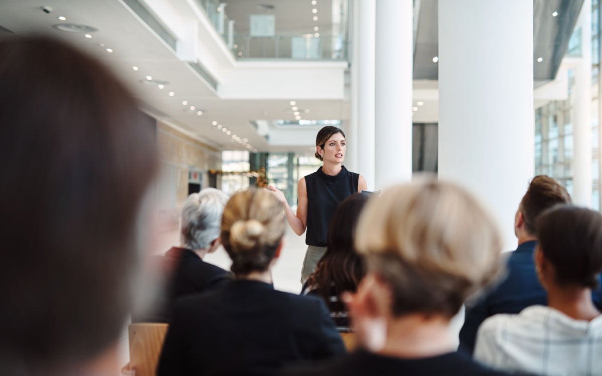 Woman speaking in front of a seated group