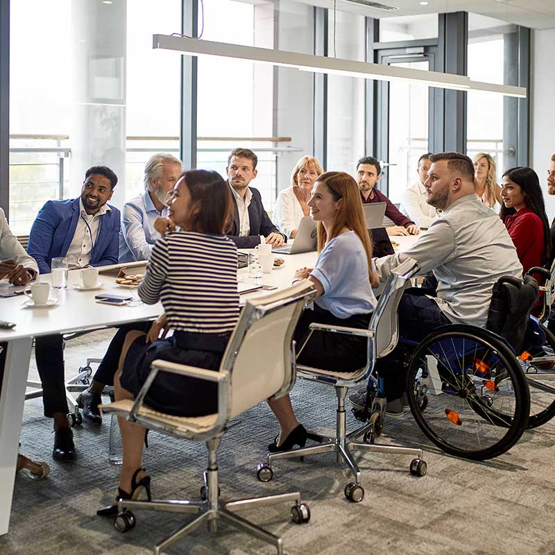 A Team of People Sat at a Table all Looking in the Same Direction