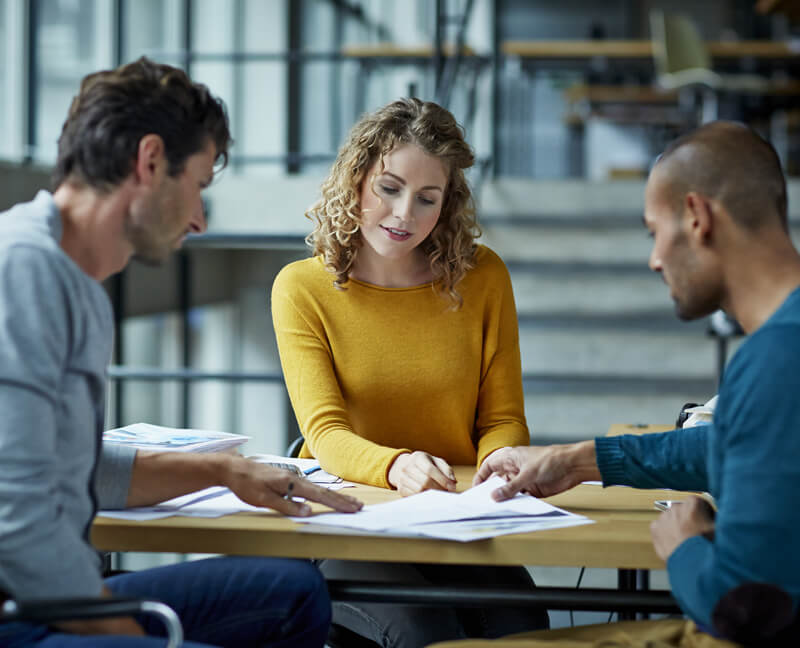 Three People Sat at a Table and Looking