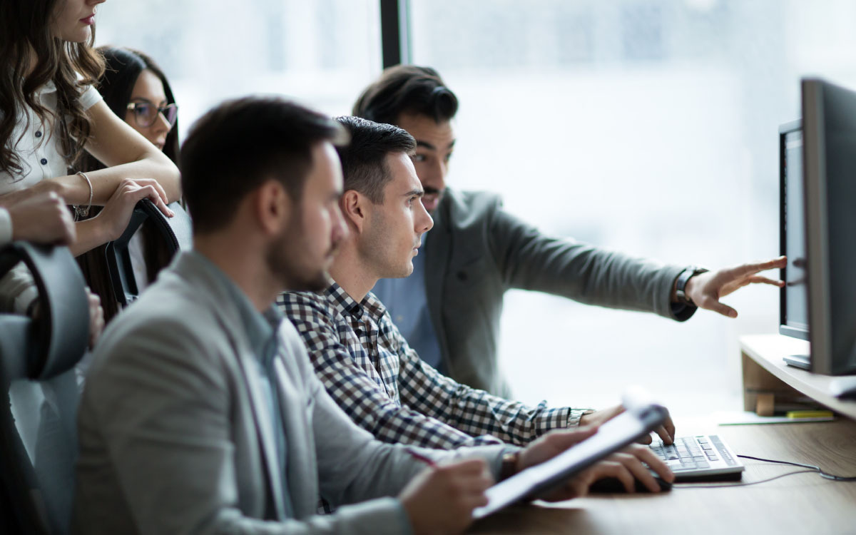 A group of people in an office looking at a computer screen