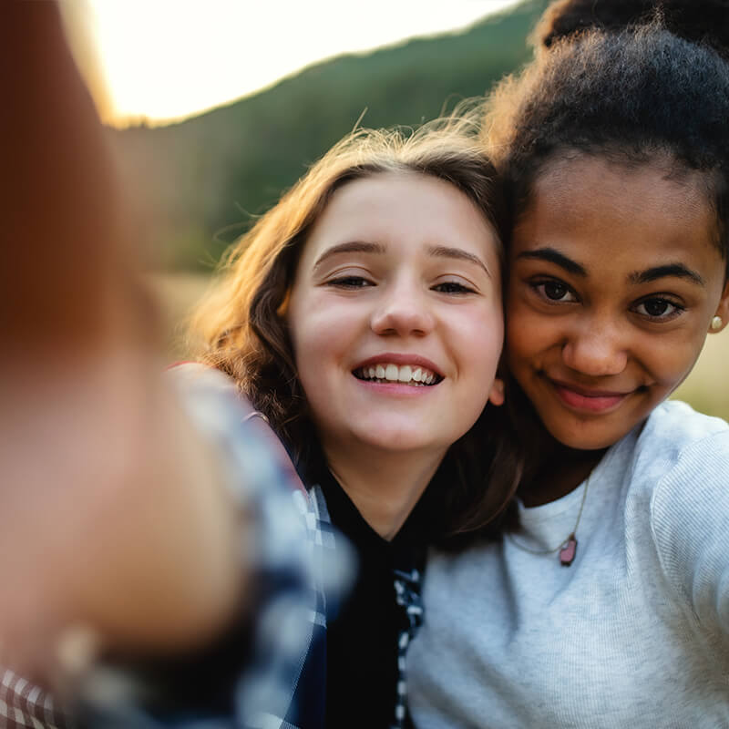 Two Girls Hugging and Looking at the Camera